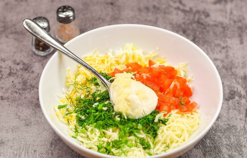 1. Этап. Пикантная закуска на чипсах: Заправьте все ингредиенты майонезом, добавьте соль и перец по вкусу, измельченный зубчик чеснока. Перемешайте все.