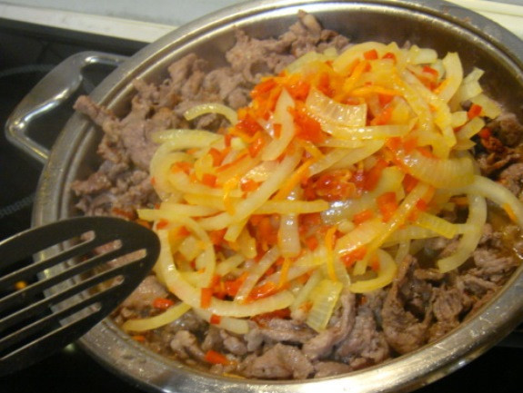 1. Этап. Баранина в сладком соусе: Посолите, поперчите мясо, верните на сковороду пассерованные овощи, перемешайте и добавьте чеснок.