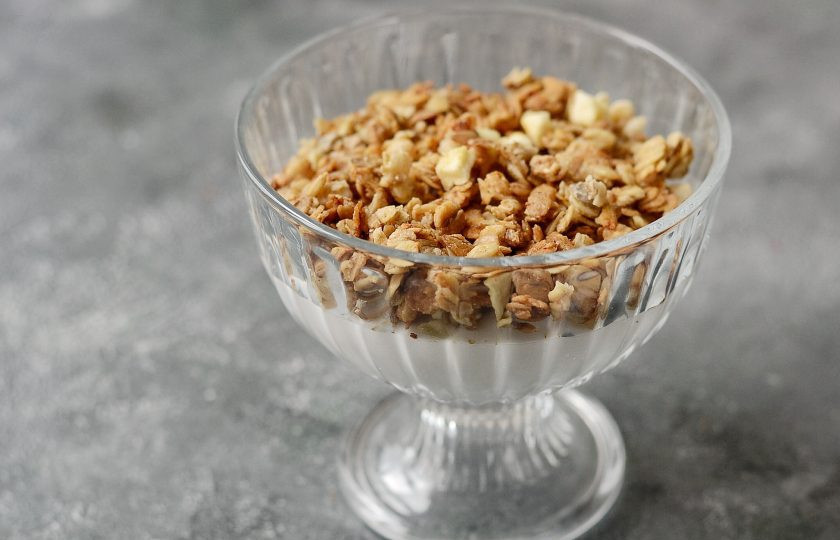 1. Этап. Кокосовое парфе: Выложите половину кокосового крема в вазочку, сверху посыпьте мюсли.