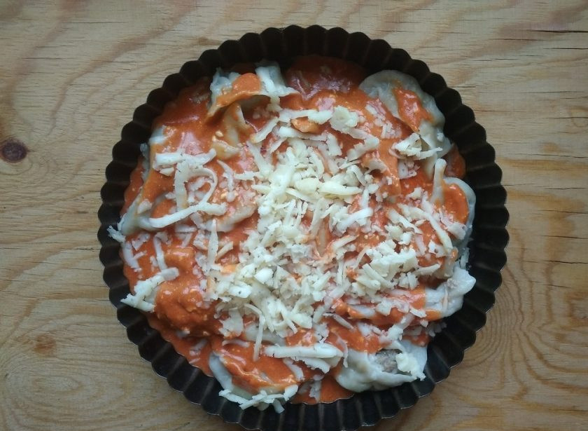 1. Этап. Пельмени в духовке под томатным соусом: 7. А сверху натрите сыр на крупной тёрке.