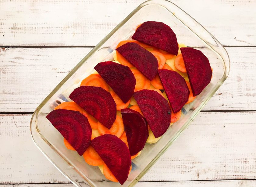 1. Этап. Печеный картофель со свеклой: Свеклу помойте, почистите, нарежьте небольшими кусочками и выложите поверх моркови.