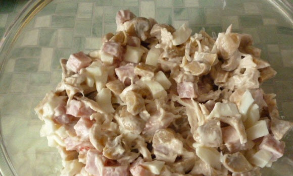 1. Этап. Салат Гнездо глухаря с грибами: В салатнице смешайте курицу, ветчину, белки, чеснок и грибы. Заправьте ингредиенты майонезом.