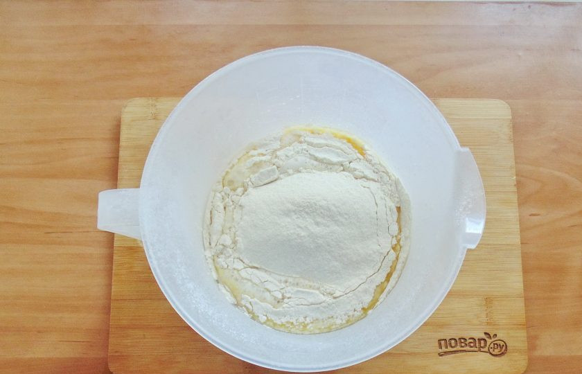 1. Этап. Дрожжевые рогалики с вишней: Постепенно просейте в ёмкость муку.