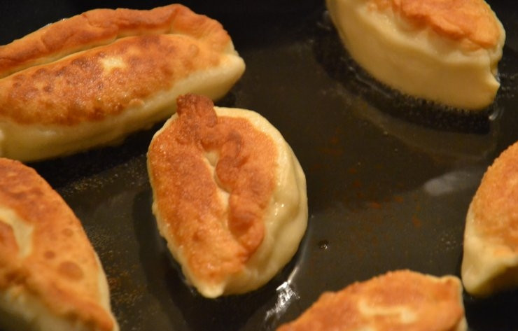 1. Этап. Пирожки с зеленым луком и яйцом: В сковороду налейте немного растительного масла, лучше брать подсолнечное. Разогрейте масло, выложите пирожки в сковороду. Обжаривайте их на каждой стороне до появления золотой корочки.