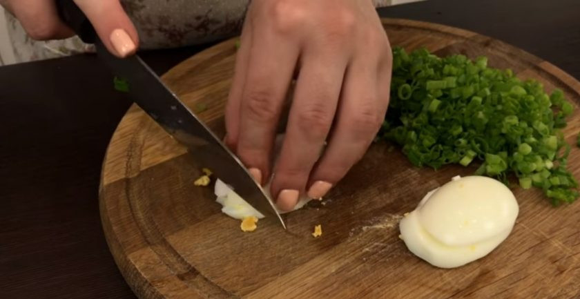 1. Этап. Закусочные оладушки с зеленым луком и яйцом: 2. Мелко нарежьте вареные яйца и зеленый лук. Добавьте нарезанное яйцо и зеленый лук в тесто, перемешайте. Разогрейте сковороду с маслом на среднем огне.