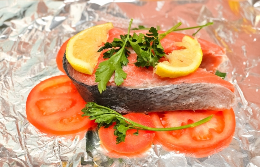 1. Этап. Стейк лосося в фольге: На фольгу выложите сначала ломтики помидора. Затем стейк лосося. Посолите его и поперчите. Добавьте, если хотите, любимых приправ. На стейк аккуратно положите ломтики лимона и веточки петрушки.