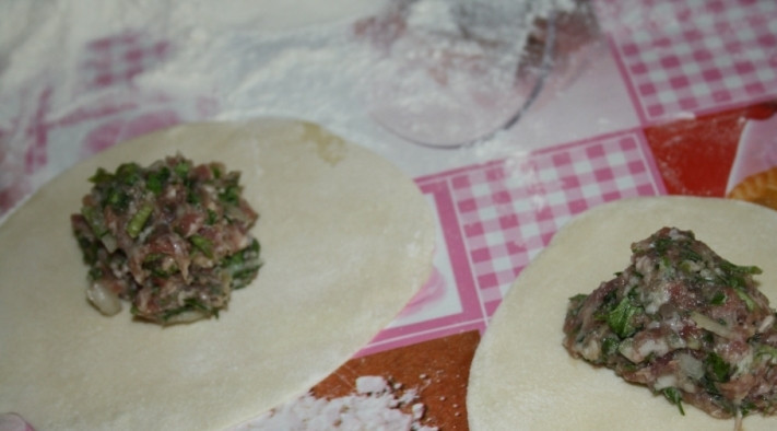 1. Этап. Манты из свинины: Тесто делим на равные кусочки, раскатываем кружки и выкладываем в середину фарш.