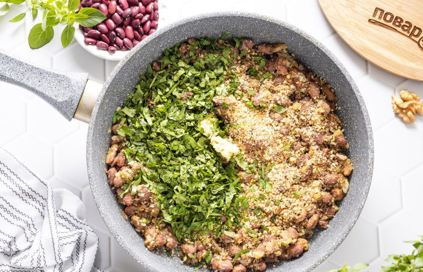 1. Этап. Лобио из красной фасоли (классический рецепт): Добавьте грецкие орехи с чесноком и мелко порубленный базилик с кинзой в сковороду. Влейте винный уксус и все перемешайте.