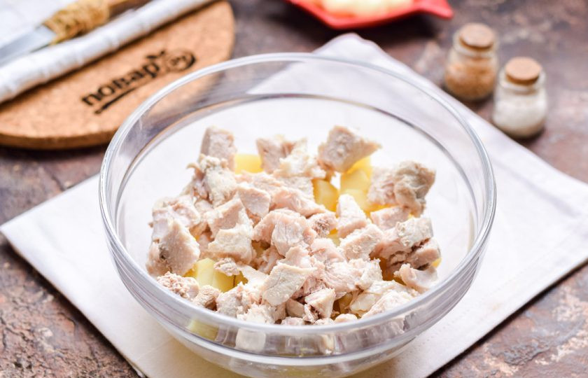 1. Этап. Мясной салат на Новый год: Вареную свинину нарежьте крупными кусочками и добавьте в салат.