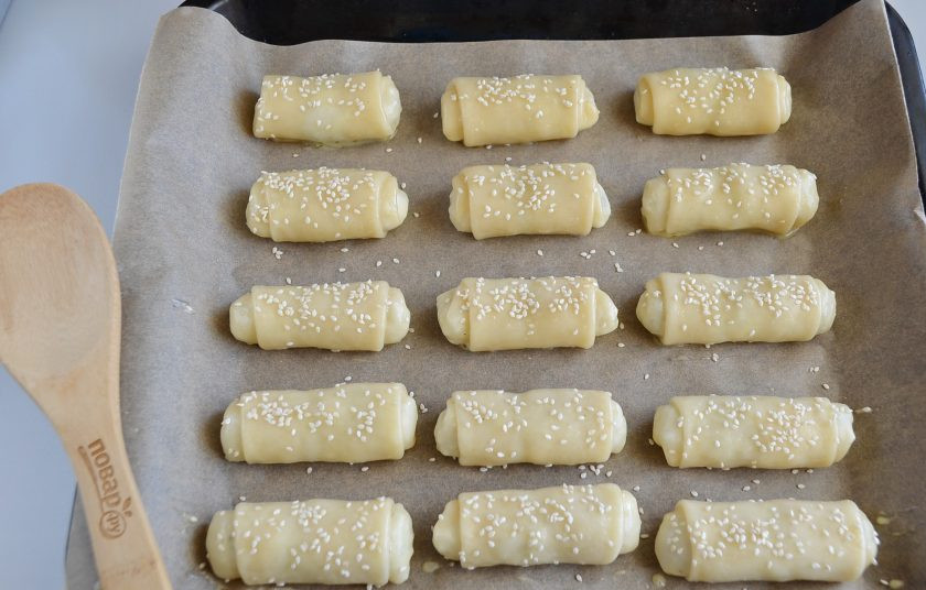 1. Этап. Молдавские пирожки с рисом Вэрзэре: Переложите пирожки на пергамент, смажьте желтком или взболтанным яйцом, посыпьте кунжутом.