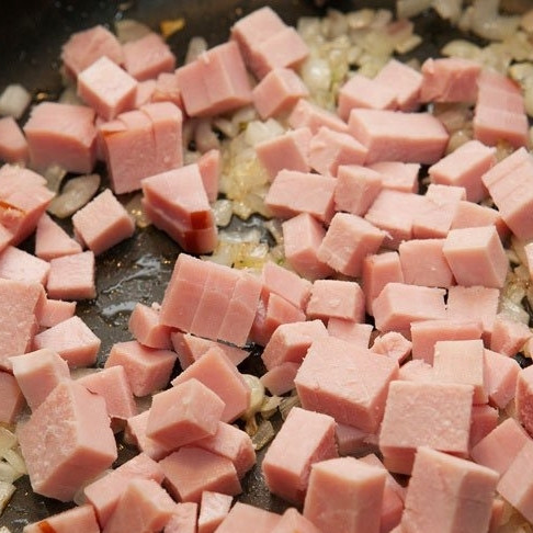 1. Этап. Яичница в духовке: Добавляем кубиками нарезанный бекон и готовим еще 4-5 минут на среднем огне, помешивая.