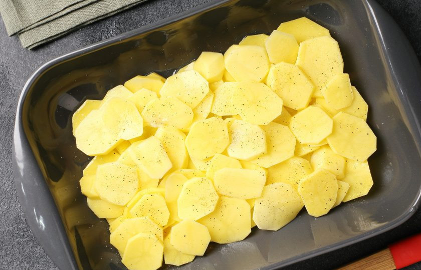 1. Этап. Запеканка из куриного филе с картошкой, грибами и сыром: Жаропрочную форму смажьте маслом. Картофель нарежьте тонкими кружочками и выложите в 2-3 слоя. Каждый слой посолите и поперчите.