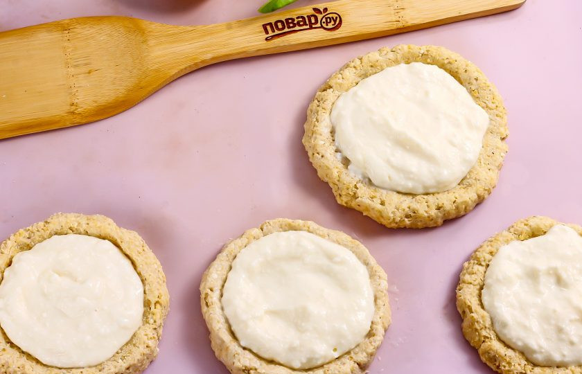 1. Этап. Полезные ватрушки с творогом: Выложите в углубления творожную начинку. Разогрейте духовку до 200 градусов и поместите в нее противень. Выпекайте примерно 20-25 минут. Затем извлеките и смажьте бортики теста оставленным желтком. Запеките еще 1-2 минуты.