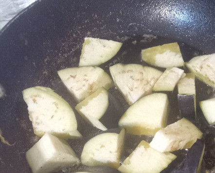 1. Этап. Острый рис с баклажанами и помидорами: Разогреть 3 столовых ложки масла на сильном огне в сковороде. Добавить баклажан, посыпать 1/4 ложкой соли. Готовить 8 минут до обжаривания, а не до готовности. Отложить на кухонную бумагу. Влить ещё 3 ложки масла на сковороду, добавить 1/4 ложку соли и готовить второй раунд баклажан ещё 8 минут.