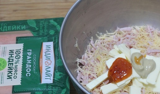 1. Этап. Закусочное печенье Малютка: В чашу выложить сосиски, сыр, добавить соус, горчицу и сливочное масло комнатной температуры. Хорошо смешать.