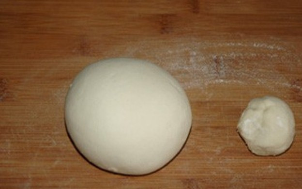1. Этап. Паровые булочки по-вьетнамски: Разделите тесто на 2 части, одна из которых должна быть в 3 раза больше.