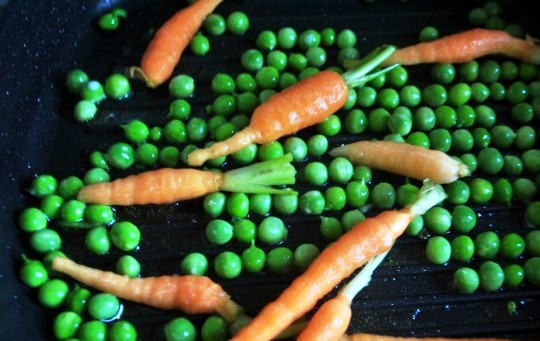 1. Этап. Гарнир к копченой рыбе: Разогрейте на сковороде масло и слегка обжарьте морковь и горошек.