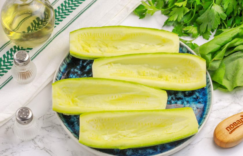 1. Этап. Кабачки с чесноком и фаршем: Кабачки промойте в воде, срежьте хвостики и разрежьте вертикально пополам. Удалите внутренность, оставляя края, чтобы лодочки оказались полыми внутри.