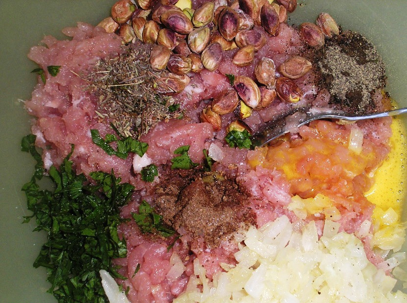 1. Этап. Запеканка с фисташками: Смешайте в миске фарш, тимьян, петрушку, фисташки, коньяк, душистый перец, соль и перец, желтки и лук с чесноком. Тщательно всё перемешайте.