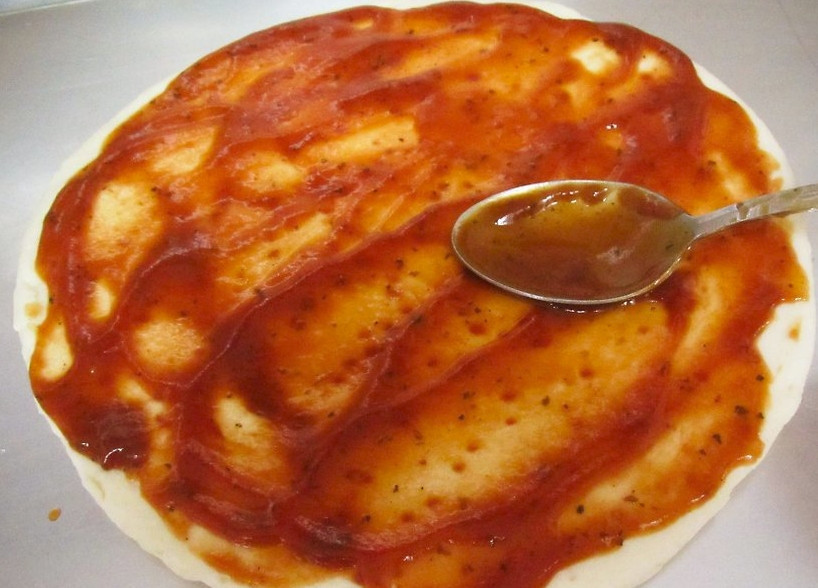 1. Этап. Пицца по-гавайски: Первым делом раскатайте тесто. Я беру дрожжевое для пиццы. Смажьте тесто соусом и присыпьте приправой для пиццы.