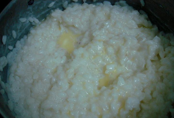 1. Этап. Рисовая запеканка с яблоками: Наливаем в кастрюлю молоко и воду, ставим на огонь. Когда жидкость закипит, добавляем сахар, всыпаем рис, уменьшаем огонь и варим кашу 10-12 минут. Когда каша будет готова, кладем в нее небольшой кусочек масла и перемешиваем.