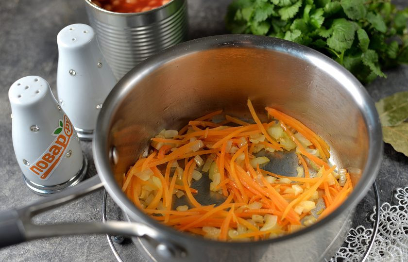 1. Этап. Фасолевый суп с кинзой: Возьмите кастрюлю или сотейник с толстым дном, влейте немного растительного масла, обжарьте на нем измельченные лук и чеснок до мягкости.