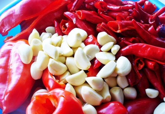 1. Этап. Аджика домашняя: На следующий день приступаем к чистке перца. Сначала удаляем семена и плодоножки у сладкого перца, очищаем чеснок, затем надеваем перчатки, разрезаем острый перец пополам и чистим его прямо под водой.