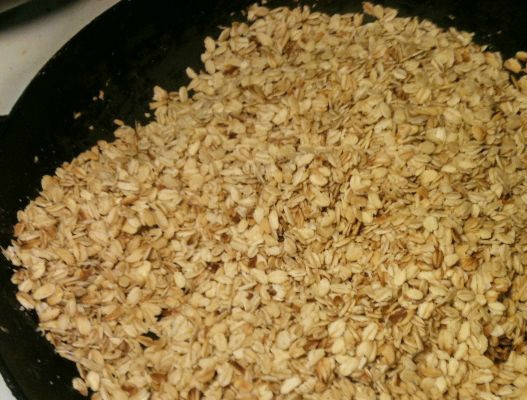 1. Этап. Овсяное печенье из овсяных хлопьев: Раскаляем сковородку. Высыпаем на нее овсяные хлопья. Обжариваем их, помешивая, на сильном огне в течение 2-х минут. Затем, кладем 30 грамм сливочного масла, убавляем огонь и обжариваем еще 5-7 минут.