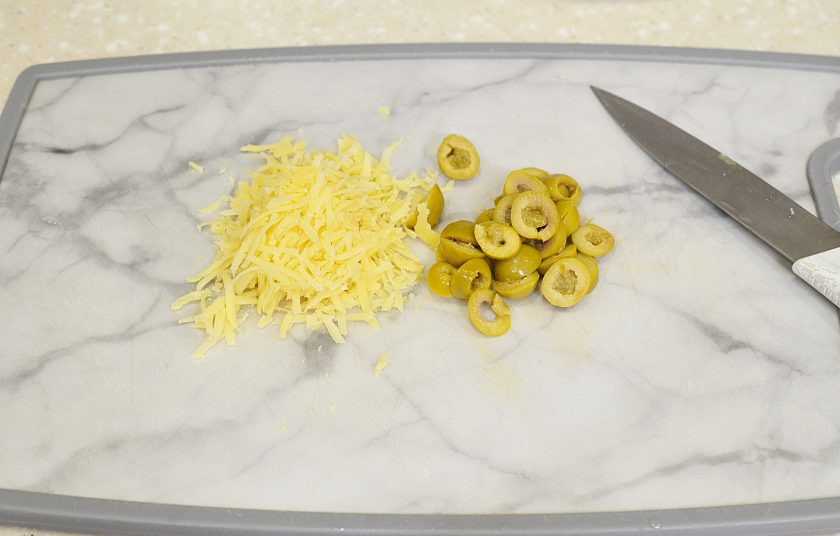 1. Этап. Салат из кальмаров и мидий: Сыр натрите, оливки нарежьте.