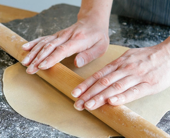 1. Этап. Лепешки Тортильяс: 3. Возьмите один шарик и раскатайте его в тонкую лепешку настолько, чтобы через него виднелась рука.