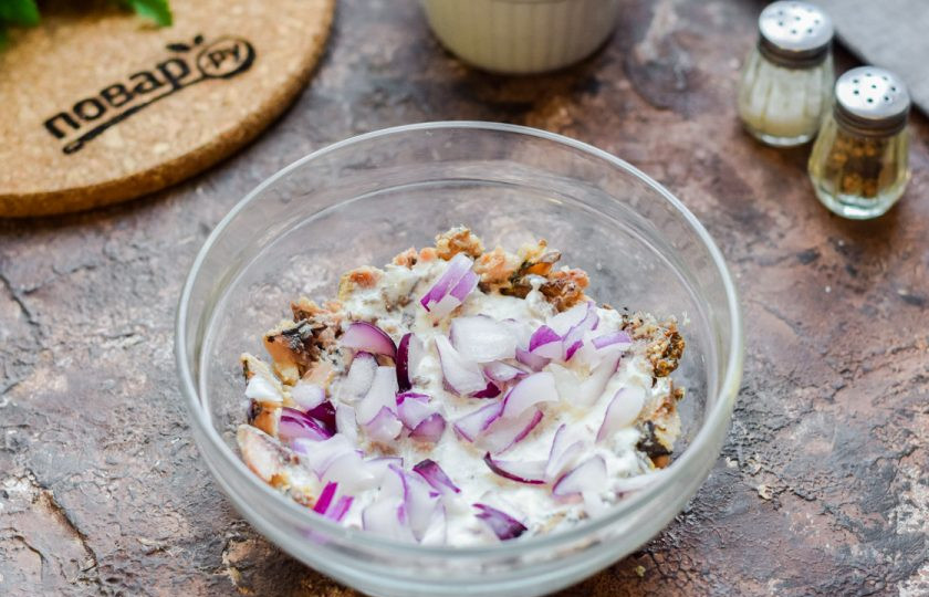 1. Этап. Салат Мимоза по Дюкану: Красный лук нарежьте небольшими кубиками и выложите поверх консервы.