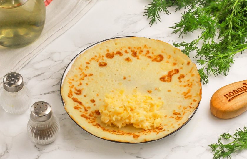 1. Этап. Блинные рулетики с начинкой: Выложите 1 ст.л. с горкой сырной начинки и заверните края блина внутрь, а после — сверните его рулетом. Нафаршируйте оставшиеся блины сырной начинкой и сверните рулетиками.