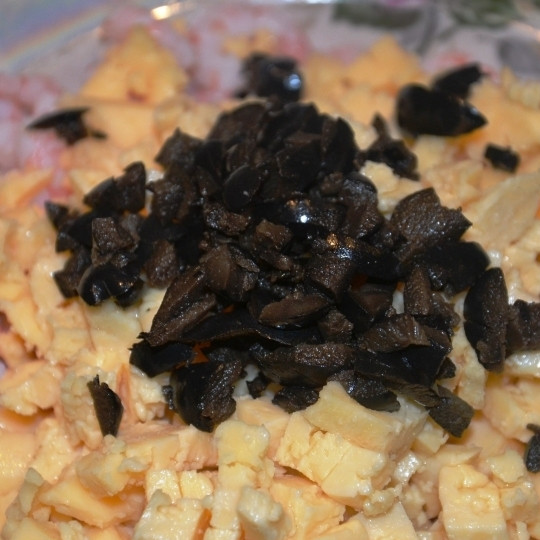 1. Этап. Салат Морская звезда: Добавляем мелко нарезанные маслины (парочку оставляем для украшения), сбрызгиваем лимонным соком, добавляем майонез и перемешиваем.