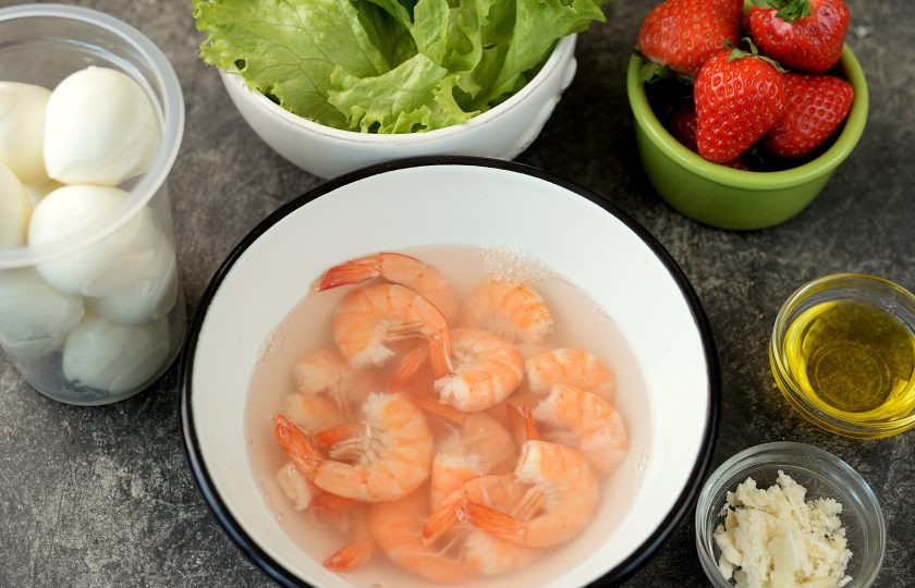 1. Этап. Салат с креветками и клубникой: Если креветки варено-мороженые, тогда разморозьте их предварительно, залейте кипятком и оставьте в нем на 1-2 минуты. Слейте воду, хвосты почистите от панциря.