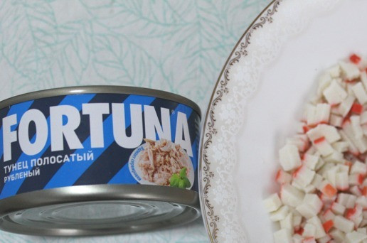 1. Этап. Рулет закусочный Рождественское полено: Пока корж остывает до теплого, сделать начинку. Крабовые палочки порезать как можно мельче. Тунец отцедить.