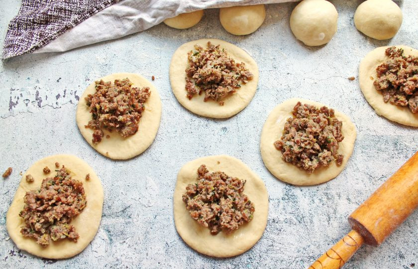 1. Этап. Пирожки с кабачком и фаршем: Подошедшее тесто разделите на одинаковые части и сформируйте шарики. Накройте тесто и оставьте на 10-15 минут для подъема. Раскатайте каждую в лепешку и разложите начинку.