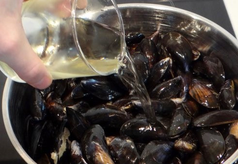 1. Этап. Cоус для мидий в створках: 4. Тушите соус на медленном огне, пока сыр не расплавится. А тем временем можно заняться мидиями. Вымойте их и пересмотрите, чтобы не было открытых. Влейте к ним сухое белое вино.