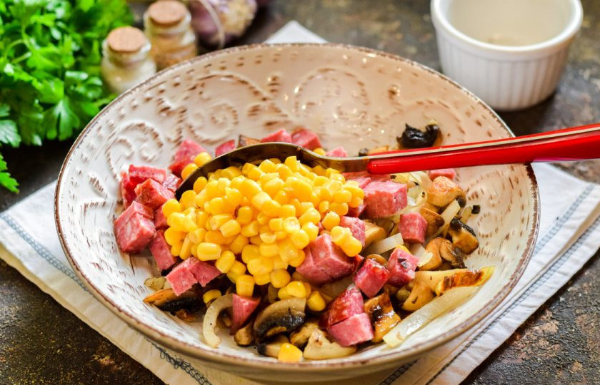 1. Этап. Салат Соренто: Добавьте в салат консервированную кукурузу.