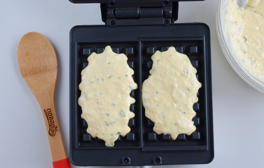 1. Этап. Сырная выпечка: Разогрейте вафельницу, если у вас антипригарная, то смазывать ее не нужно, тем более что в составе теста есть растительное масло, прилипать ничего не будет. Если вафельница, как у меня, то на каждую половинку выложите по 2 ст.л. теста. Если вафельница квадратная (из 4 квадратиков), то по 1 ст.л. будет в самый раз.