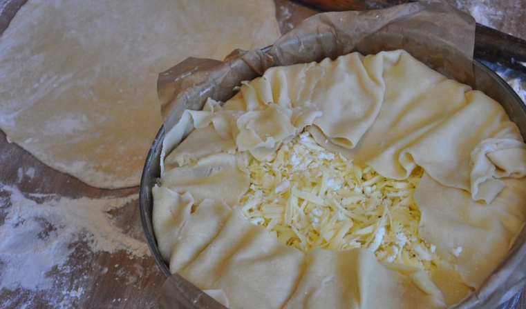 1. Этап. Ачма по-аджарски: Верхним слоем получается сыр. Подворачиваем края свисающего теста к центру (как на фото).