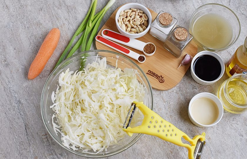 1. Этап. Китайский салат из капусты: Капусту тонко нашинкуйте. Очень удобно это делать обычной горизонтальной овощечисткой. Выложите в глубокую миску.