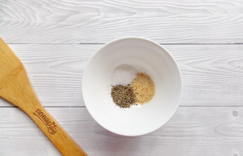 1. Этап. Картофельные дольки с чесноком: В мисочку выложите чесночный порошок, сушеный базилик, соль и перец черный молотый. Перемешайте специи.