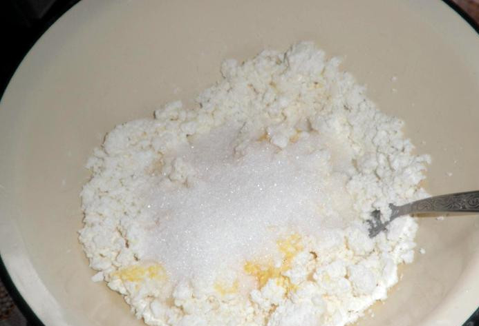 1. Этап. Творожный торт на скорую руку: Творог тщательно разминаем вилкой или перетираем через сито, выкладываем в миску. Добавляем к творогу яйца и сахар по вкусу, хорошенько все перемешиваем до однородного состояния.