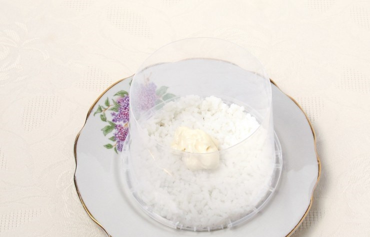 1. Этап. Салат Мимоза (рецепт с рисом): В кастрюле вскипятите воду, бросьте в нее рис, посолите и отварите до готовности. Возьмите кулинарное кольцо, поставьте его в центр тарелки для подачи. Положите в нее слой риса, слегка утрамбуйте. Положите на рис столовую ложку майонеза и разровняйте.