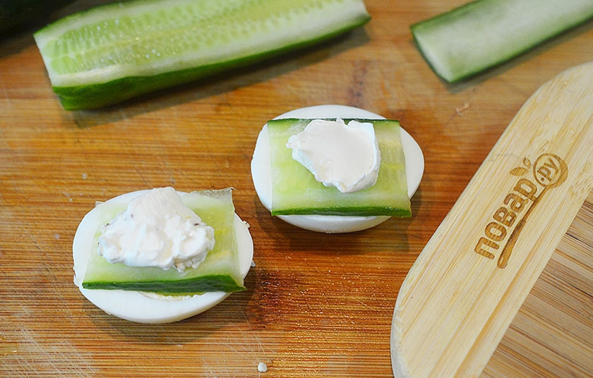 1. Этап. Ассорти из канапе: Выложите на яйца по ломтику огурца, а на него — немного соуса из 1-го варианта канапе.