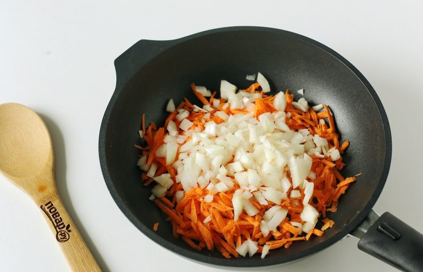 1. Этап. Гороховый суп с карри: Тем временем разогрейте сковороду с маслом. Выложите тертую морковь и нарезанный кубиками лук.
