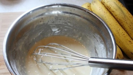 1. Этап. Бананы в кляре простые: 1. В миску вбейте куриные яйца, добавьте немного воды, соды, сахарной пудры, кокосовой стружки и муки, хорошенько перемешайте и введите воду, чтобы получилась жидкая консистенция.