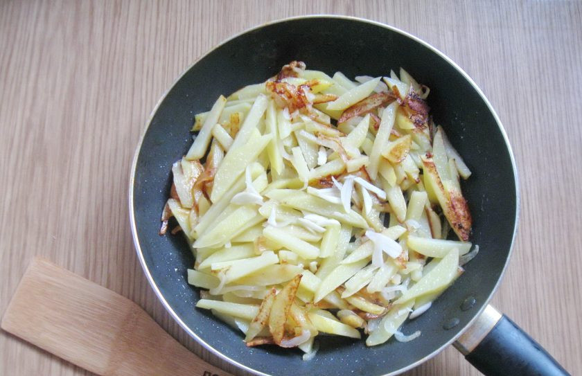 1. Этап. Картошка жареная с луком и чесноком: Когда картофель будет готов, добавьте нарезанный или измельченный чеснок. Посолите и поперчите по вкусу.