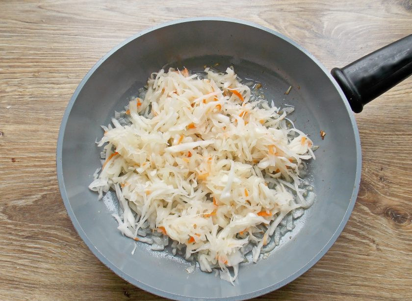 1. Этап. Свиные ножки с капустой: Капусту промойте, отожмите и положите в сковороду с обжаренным луком.