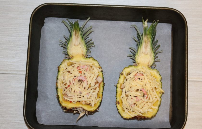 1. Этап. Фаршированные ананасы: Форму для запекания застелите пекарской бумагой. Выложите фаршированный ананас. Отправьте в разогретую до 200 градусов на 30 минут.